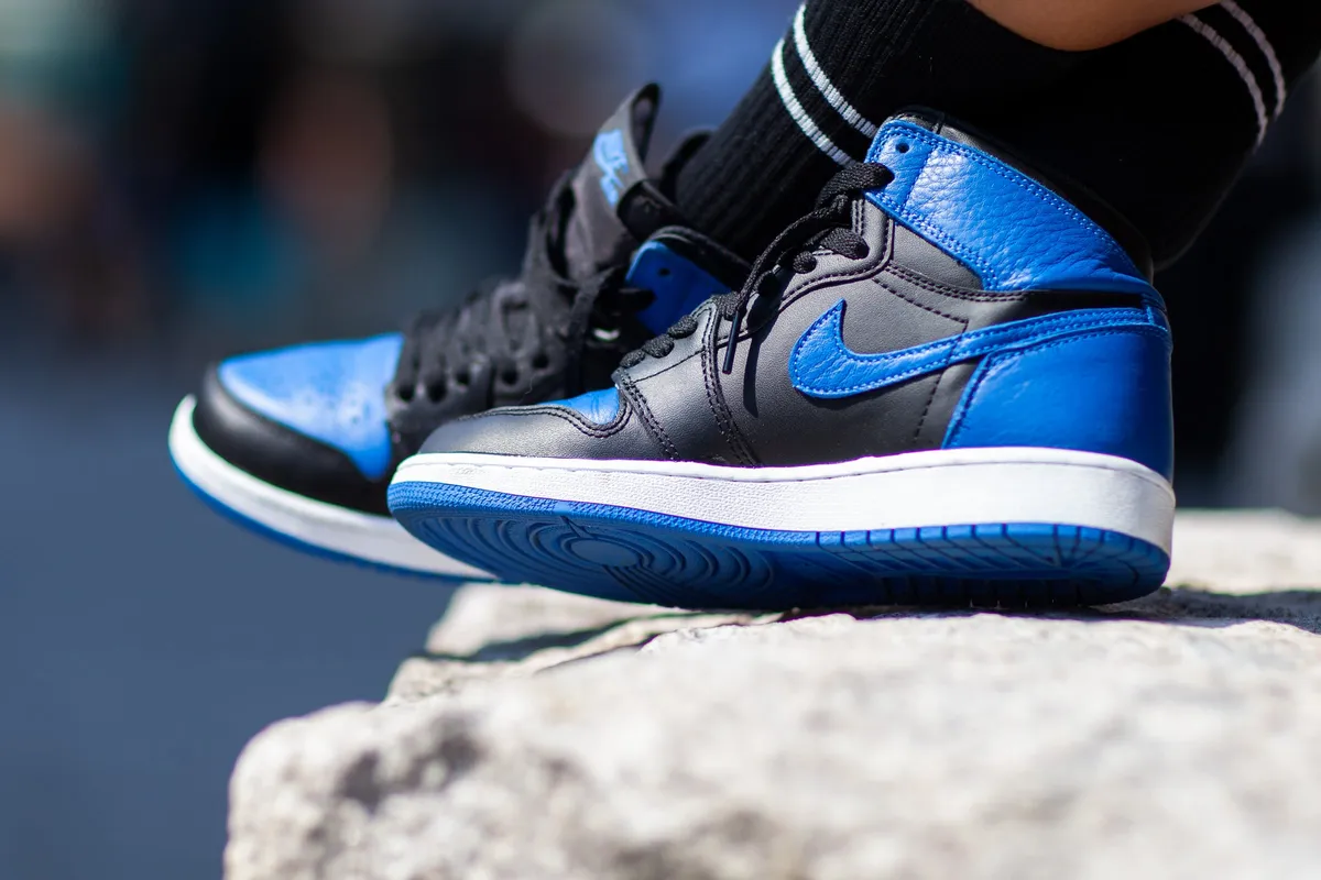 Close-up of a blue and black leather high-top sneaker resting on a granite block
