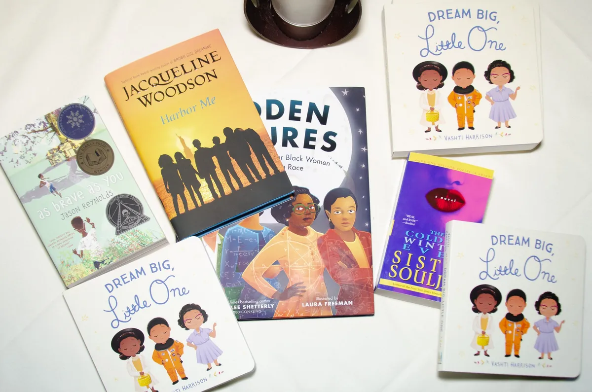 Children's books celebrating Black girls and women arranged on a white tablecloth